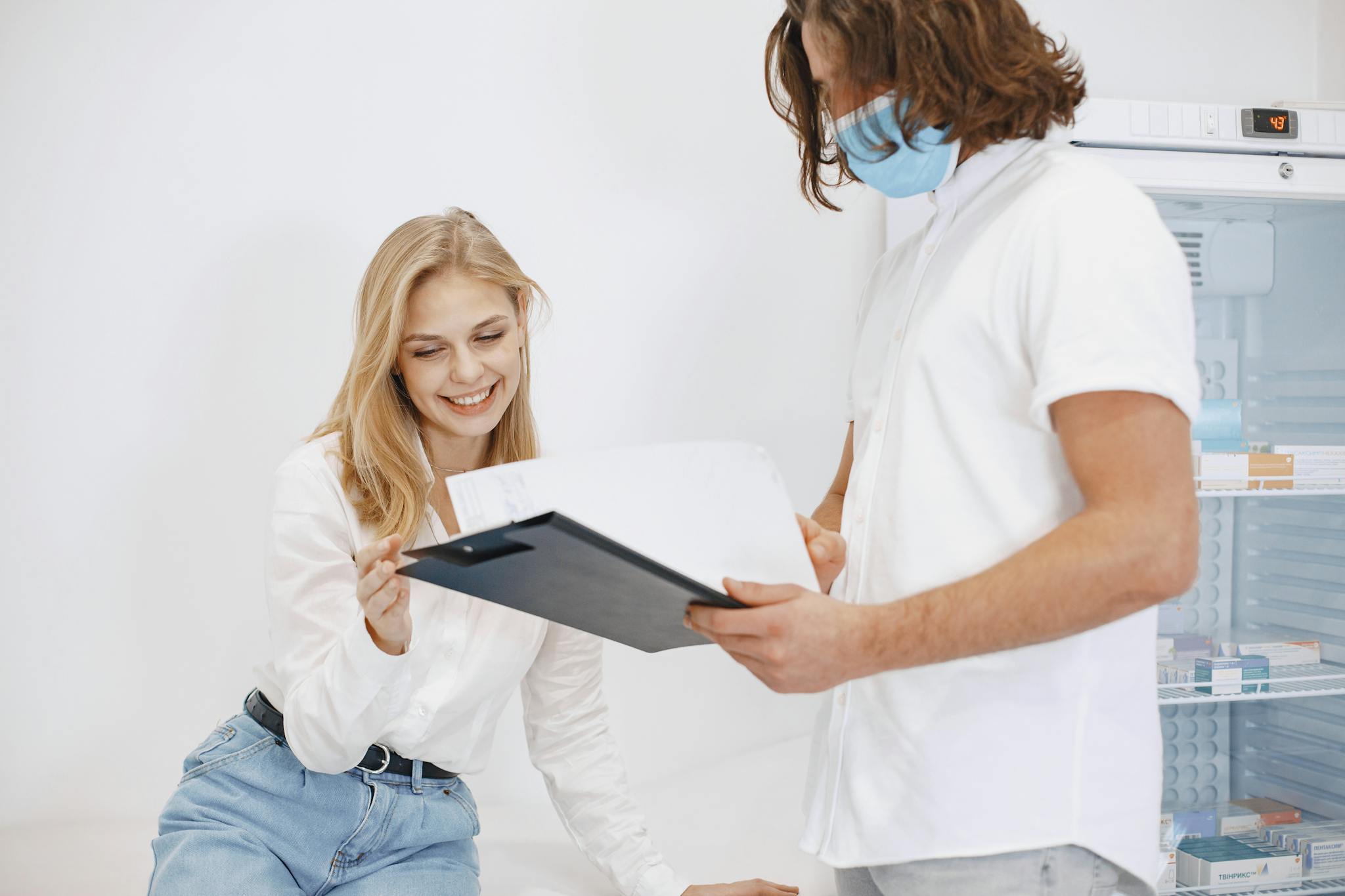 A patient happily reviews her medical results with a doctor in a clinic setting.